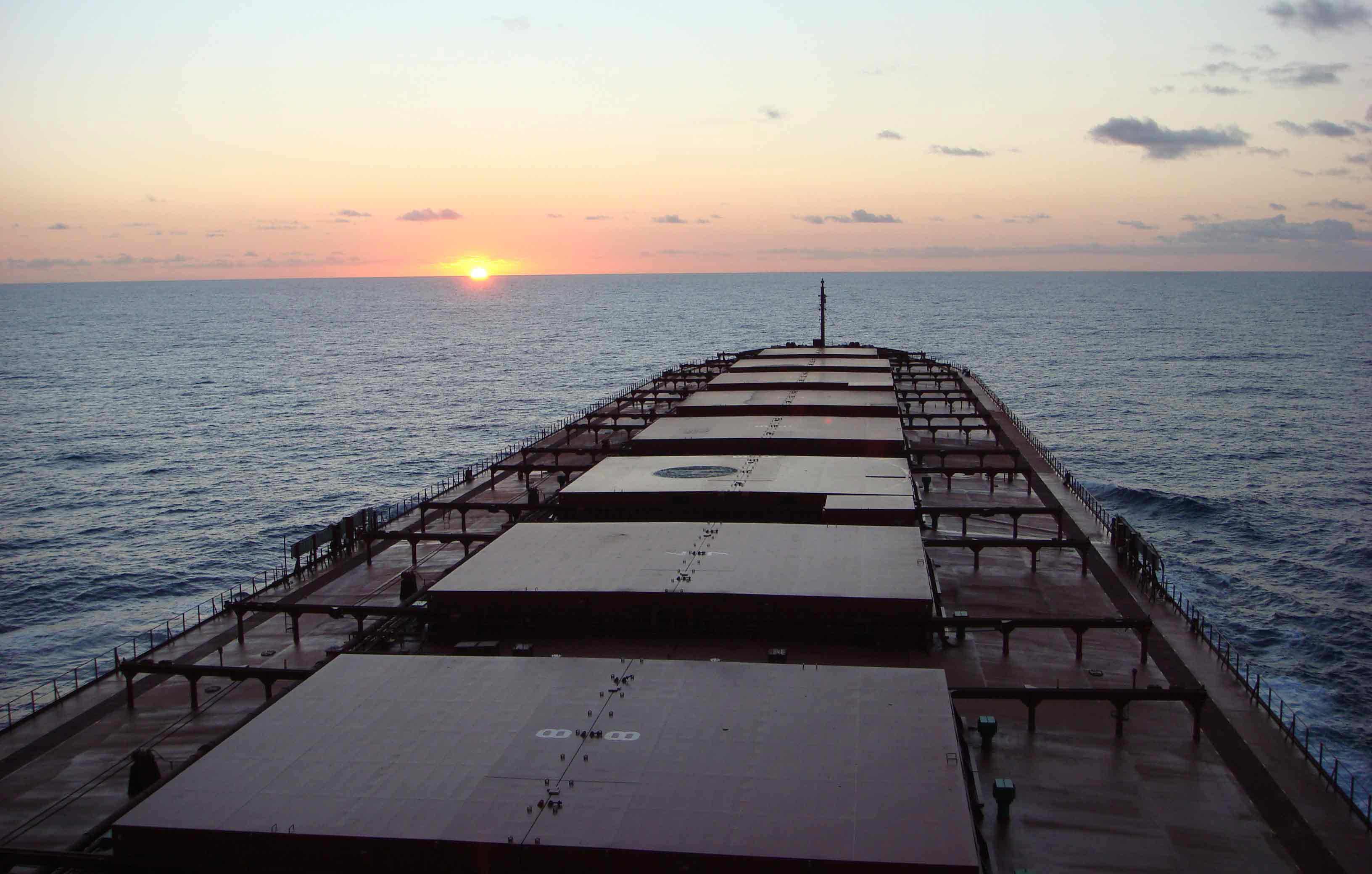 Sun setting behind an Ofer Global ship