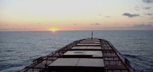Sun setting behind an Ofer Global ship